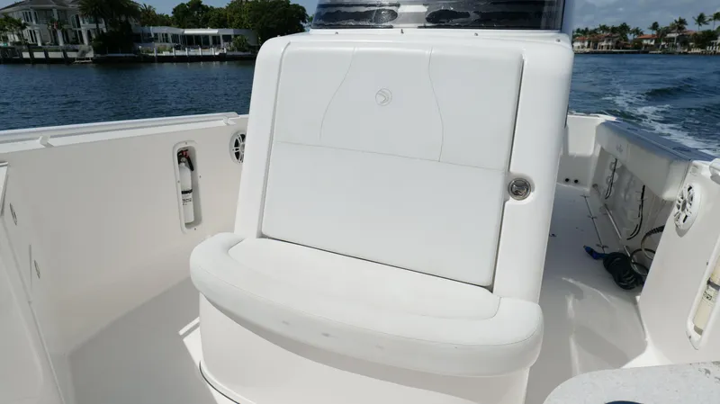 Slide: The Image of 2017 Edgewater 262CC boat interior with white seating and water view. - 46