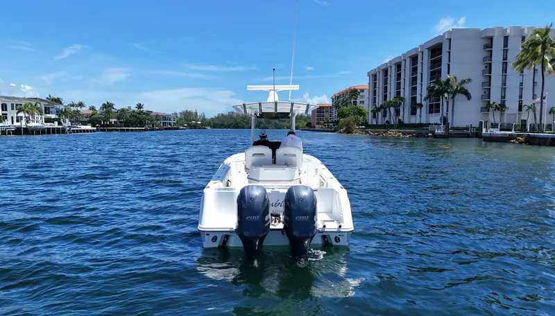 Slide: The Image of 2017 Edgewater 262CC boat cruising on a sunny day near waterfront buildings. - 7