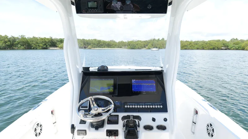 Slide: The Image of 2017 Edgewater 262CC boat console with navigation screens on a calm lake. - 9