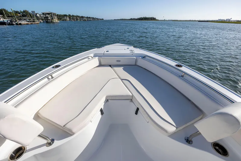 Slide: The Image of 2023 Sea Hunt Ultra 234 boat with spacious seating on calm water. - 10