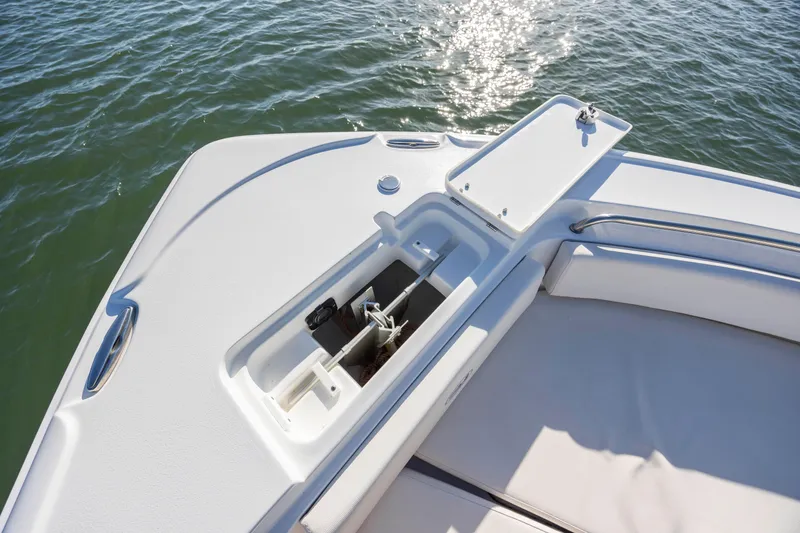 Slide: The Image of 2023 Sea Hunt Ultra 234 boat anchor compartment on calm water. - 11