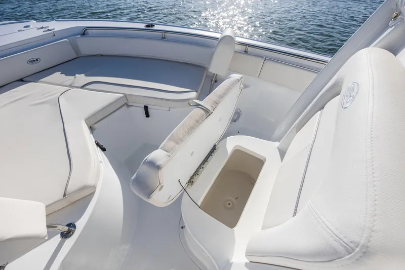 Slide: The Image of 2023 Sea Hunt Ultra 234 boat interior with seating and storage, on water. - 12