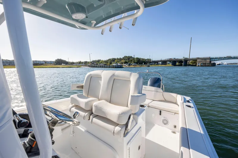 Slide: The Image of 2023 Sea Hunt Ultra 234 boat on water, featuring comfortable seating and scenic bridge view. - 13