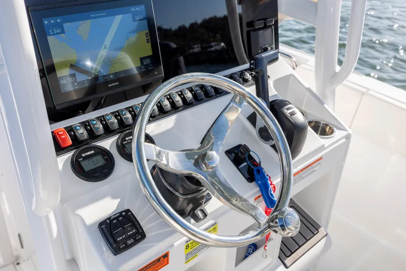Slide: The Image of 2023 Sea Hunt Ultra 234 boat dashboard with steering wheel and navigation display. - 16