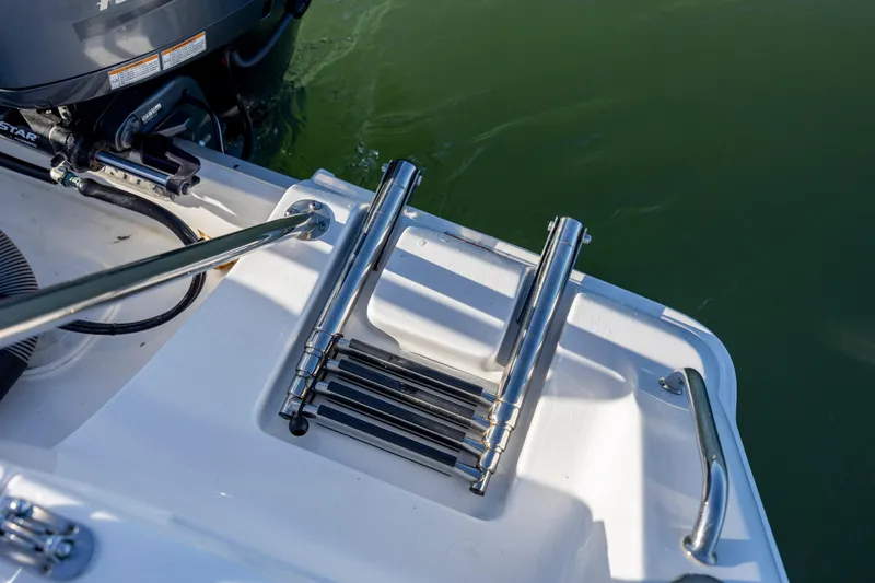 Slide: The Image of 2023 Sea Hunt Ultra 234 boat ladder and engine detail. - 20