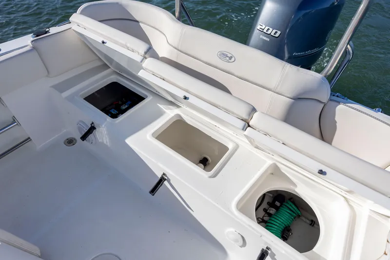 Slide: The Image of 2023 Sea Hunt Ultra 234 boat interior with storage compartments and Yamaha 200 engine. - 21