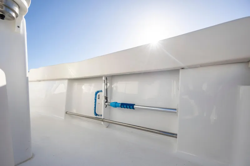Slide: The Image of 2023 Sea Hunt Ultra 234 boat interior with cleaning brush and rod storage. - 22