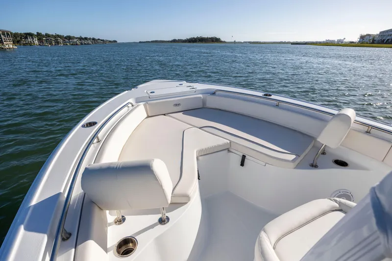 Slide: The Image of 2023 Sea Hunt Ultra 234 boat on calm water, featuring spacious seating and sleek design. - 9