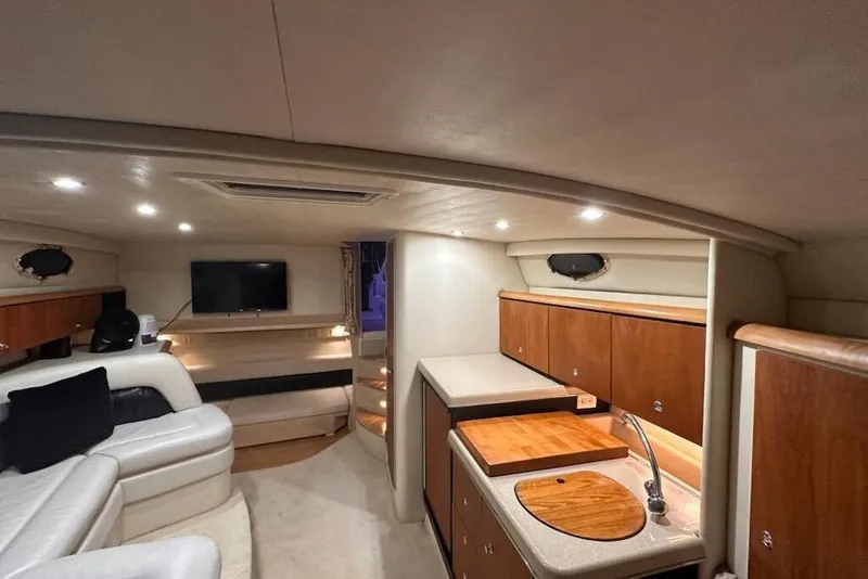 Slide: The Image of 1998 Wellcraft 3200 Martinique yacht interior with cozy seating, kitchenette, and modern lighting. - 13