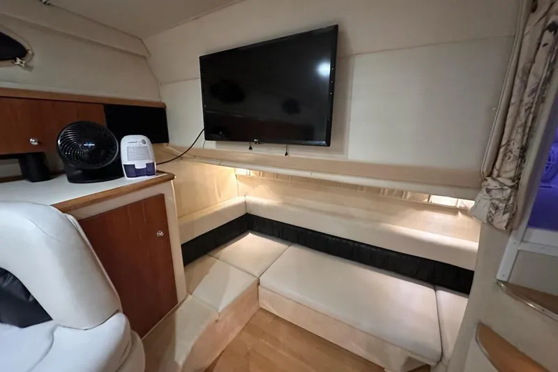 Slide: The Image of 1998 Wellcraft 3200 Martinique cabin interior with TV, seating, and wooden cabinetry. - 14