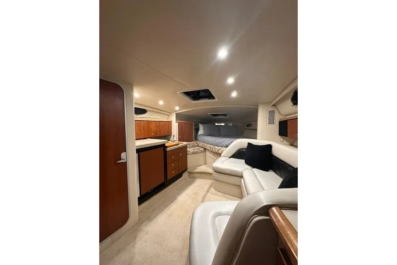 Slide: The Image of 1998 Wellcraft 3200 Martinique cabin interior with seating, kitchenette, and bed. - 16