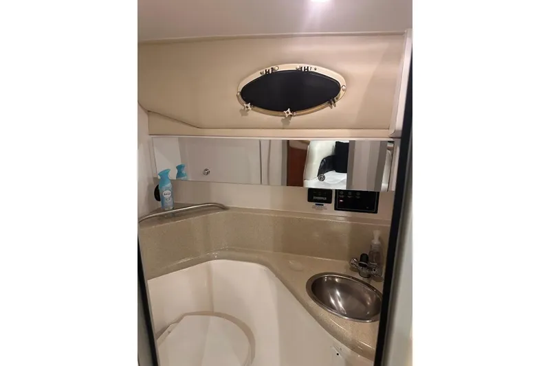 Slide: The Image of 1998 Wellcraft 3200 Martinique boat bathroom with sink, mirror, and porthole window. - 18