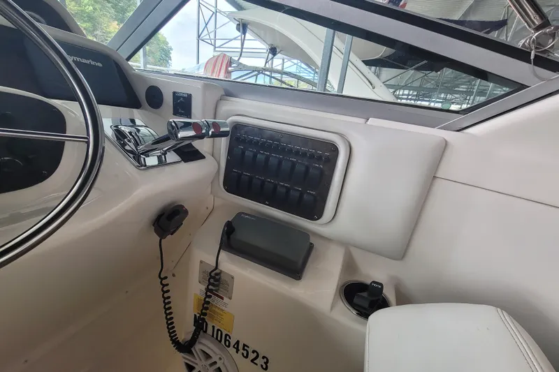 Slide: The Image of 1998 Wellcraft 3200 Martinique boat cockpit with control panel and steering wheel. - 24