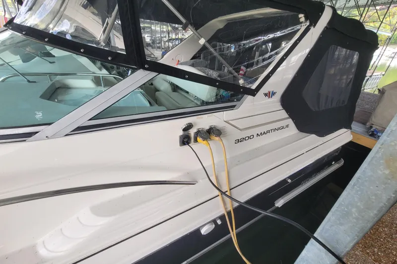 Slide: The Image of 1998 Wellcraft 3200 Martinique boat docked with power cables connected. - 3