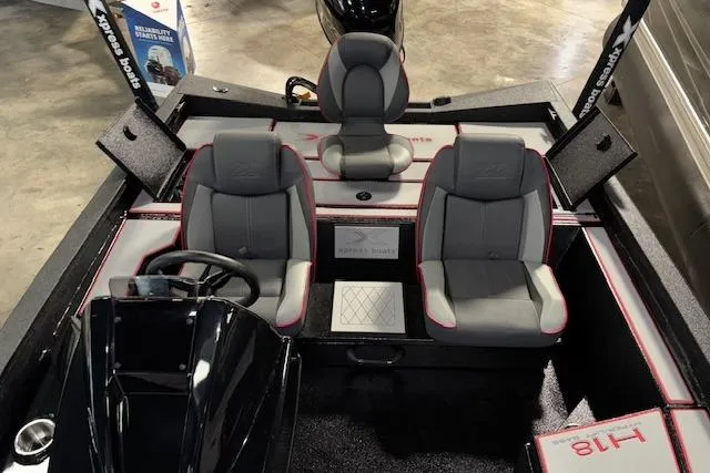 Slide: The Image of 2026 Xpress H18 Bass boat interior with three seats and steering console. - 18