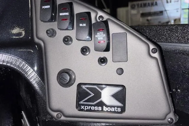 Slide: The Image of Control panel of 2026 Xpress H18 Bass boat with switches and logo. - 24