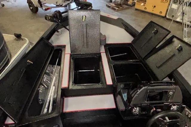 Slide: The Image of 2026 Xpress H18 Bass boat interior with open storage compartments in a garage setting. - 27