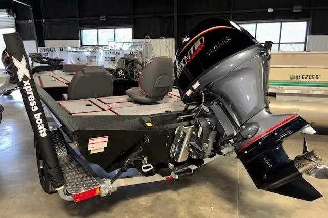 Slide: The Image of 2026 Xpress H18 Bass boat with powerful outboard motor in showroom setting. - 8