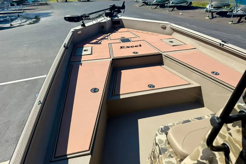 Slide: The Image of 2019 Excel 230 Bay Pro boat interior with storage compartments and camouflage seating. - 12