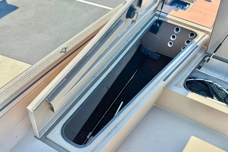Slide: The Image of 2019 Excel 230 Bay Pro boat storage compartment with open lid, showcasing interior space. - 14