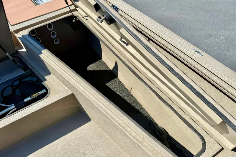 Slide: The Image of 2019 Excel 230 Bay Pro boat storage compartment with open hatch, showing interior details. - 15