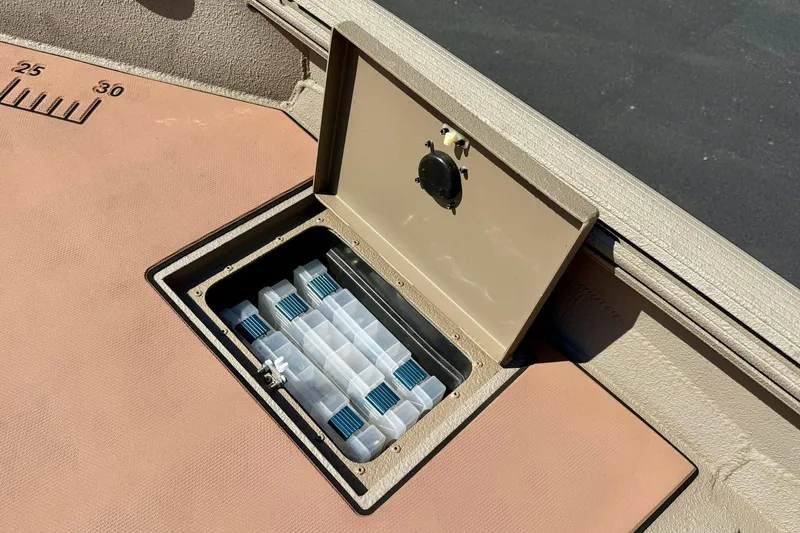 Slide: The Image of 2019 Excel 230 Bay Pro boat storage compartment with organized tackle boxes. - 20