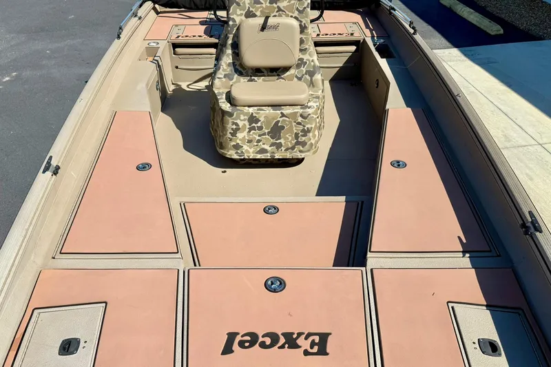 Slide: The Image of 2019 Excel 230 Bay Pro boat interior with camouflage seat and storage compartments. - 22