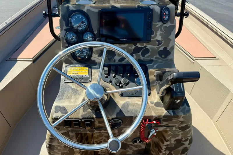 Slide: The Image of 2019 Excel 230 Bay Pro boat dashboard with camo design, steering wheel, and navigation controls. - 3