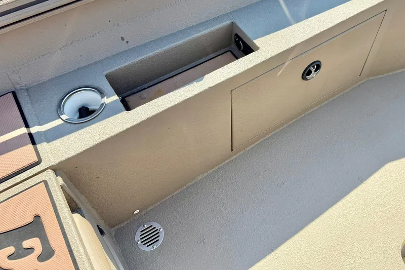 Slide: The Image of 2019 Excel 230 Bay Pro boat interior with storage compartment and cup holder. - 32