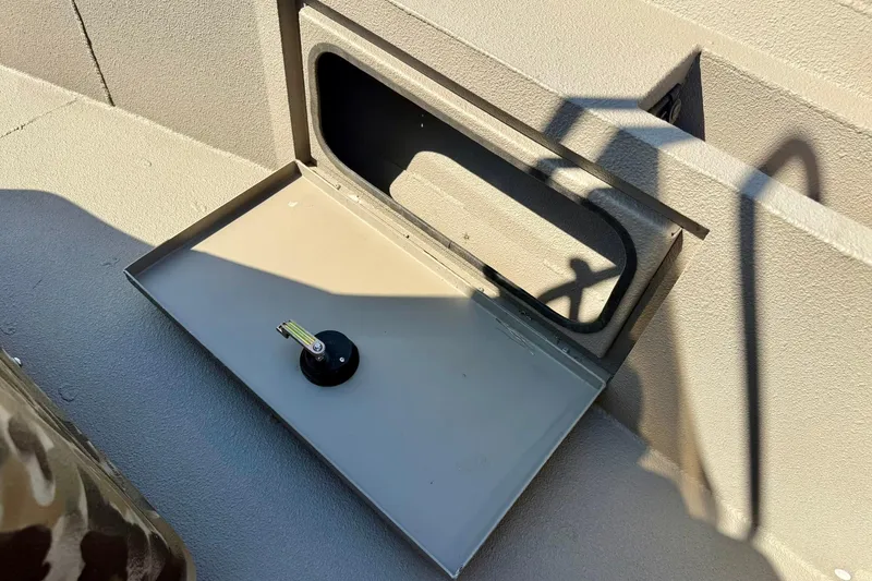 Slide: The Image of Open storage compartment on 2019 Excel 230 Bay Pro boat with key inside. - 37