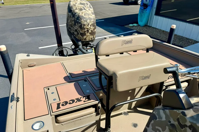 Slide: The Image of 2019 Excel 230 Bay Pro boat interior with seating and camouflage motor cover. - 39