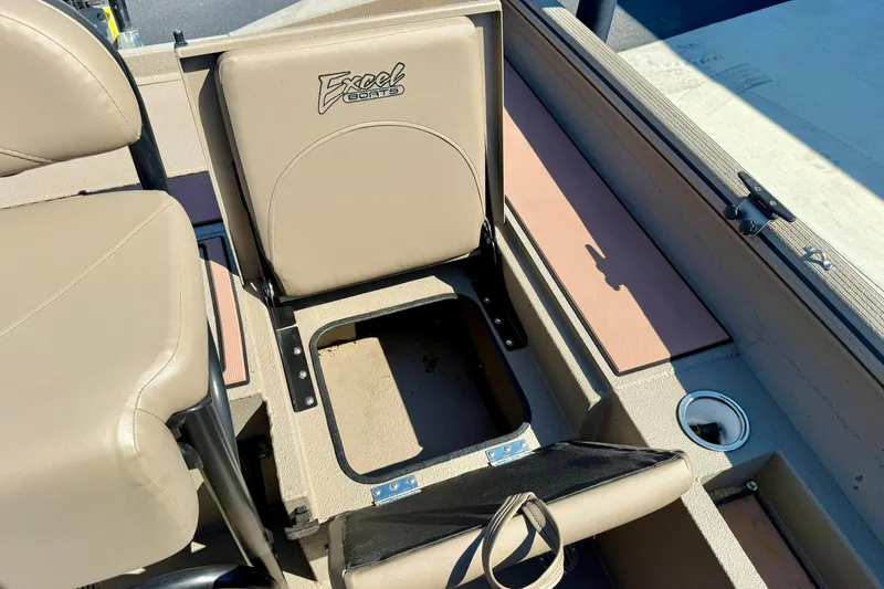 Slide: The Image of 2019 Excel 230 Bay Pro boat interior with beige seating and storage compartment. - 47
