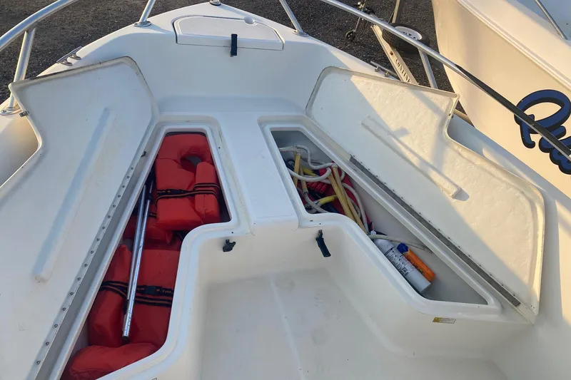 Slide: The Image of Open storage compartments on a 1997 Hydra-Sports 1800 CC boat, containing life jackets and equipment. - 3