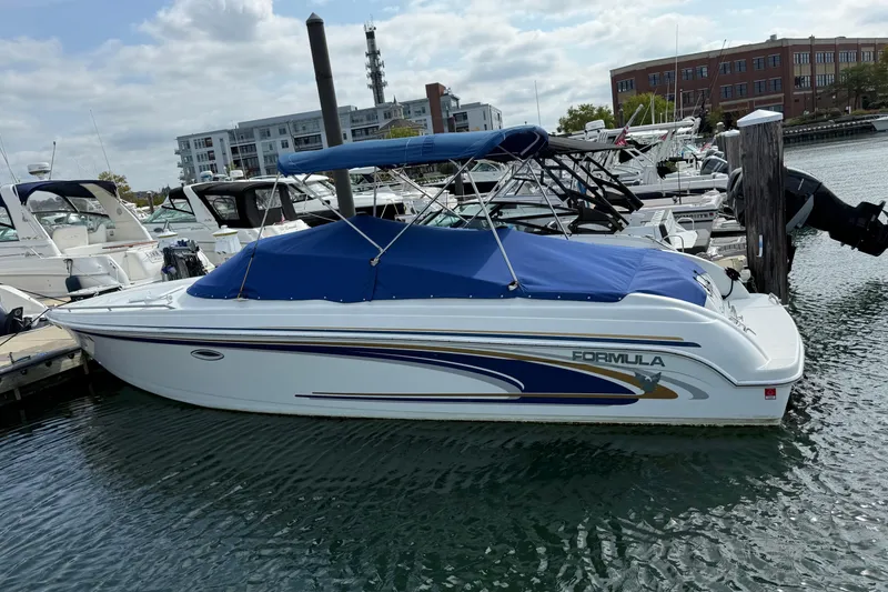 Slide: The Image of 2002 Formula 260 Sun Sport boat docked in a marina with blue cover. - 1