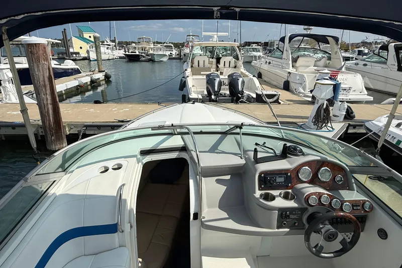 Slide: The Image of 2002 Formula 260 Sun Sport boat docked at marina, featuring sleek dashboard and spacious seating. - 10