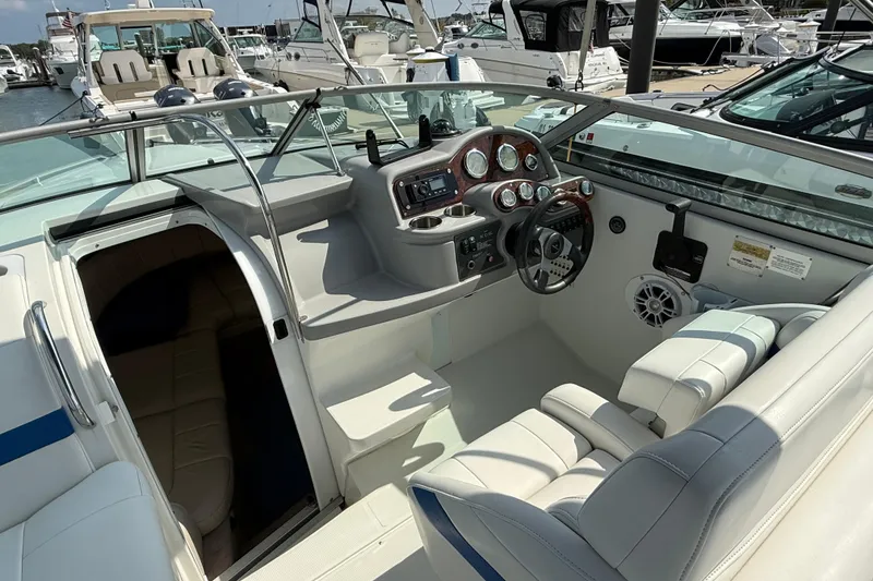Slide: The Image of 2002 Formula 260 Sun Sport boat interior with steering wheel and seating at marina. - 13