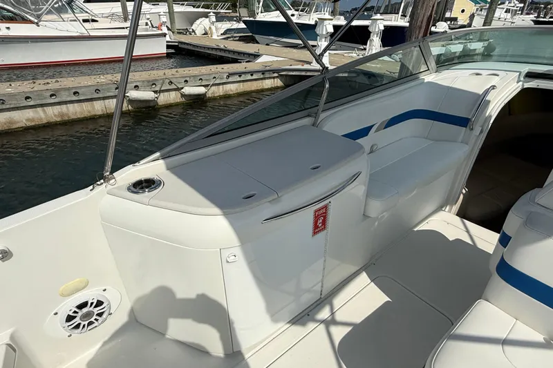 Slide: The Image of 2002 Formula 260 Sun Sport boat interior with seating and storage, docked at marina. - 14