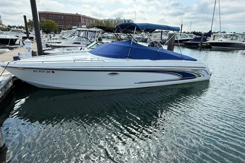 Slide: The Image of 2002 Formula 260 Sun Sport boat docked in marina, blue cover, calm water. - 2