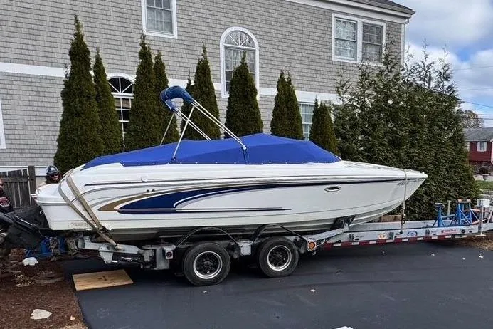 Slide: The Image of 2002 Formula 260 Sun Sport boat on trailer, covered with blue tarp, parked near house. - 3