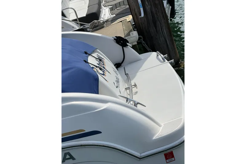 Slide: The Image of 2002 Formula 260 Sun Sport boat docked, featuring sleek white design and blue cover. - 7