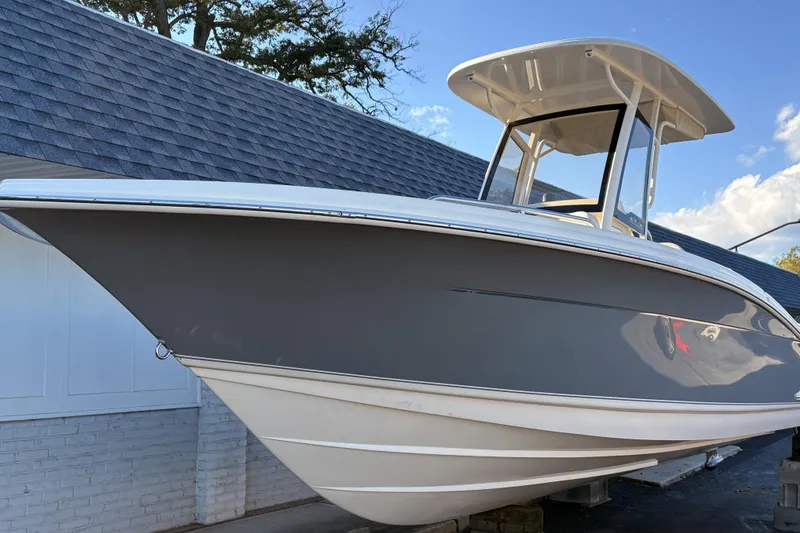 The Image of 2026 Scout 215 XSF boat with sleek design, docked under a clear blue sky. - 0