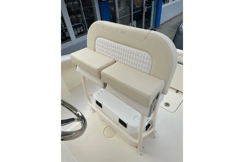 Slide: The Image of 2026 Scout 215 XSF boat seat with white cushioned design and integrated cooler. - 12