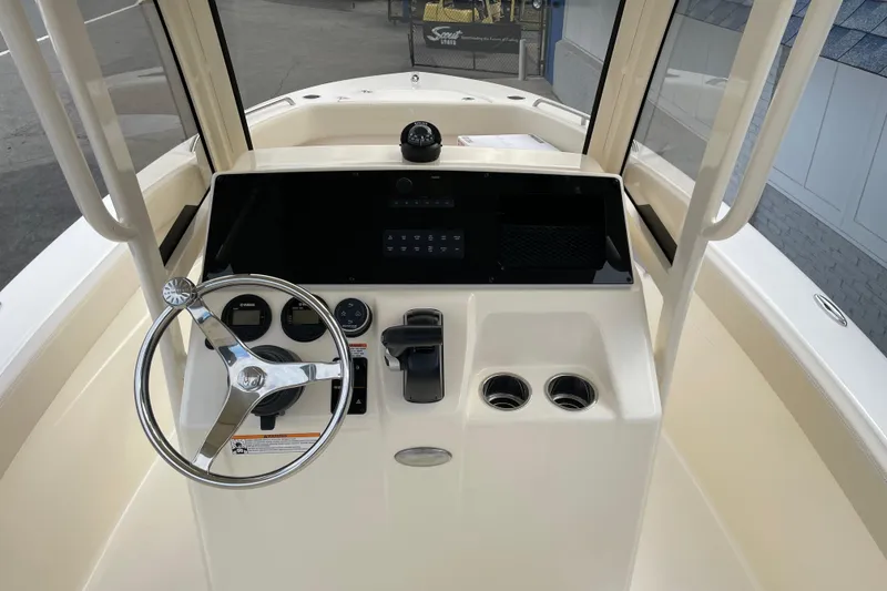Slide: The Image of 2026 Scout 215 XSF boat helm with steering wheel and control panel. - 13