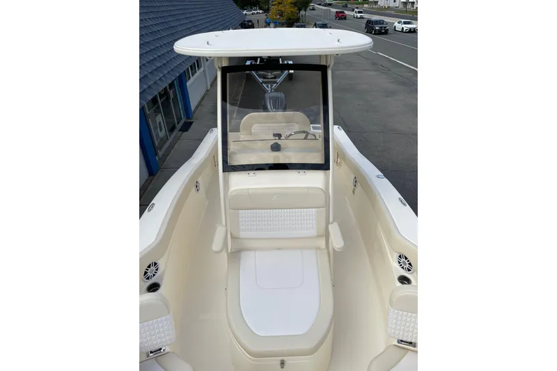 Slide: The Image of 2026 Scout 215 XSF boat interior with seating and console, parked on a street. - 17