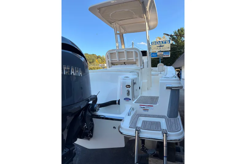 Slide: The Image of 2026 Scout 215 XSF boat with Yamaha engine, rear view, docked under clear sky. - 20