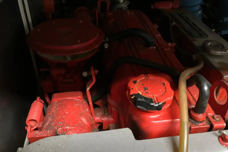 Slide: The Image of Engine compartment of a 1987 President 37 Sundeck boat, featuring a red engine. - 70