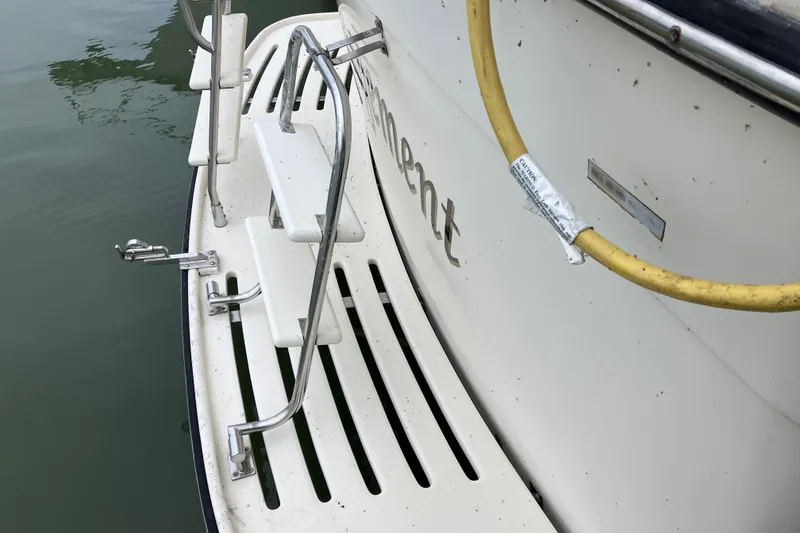 Slide: The Image of 1987 President 37 Sundeck boat stern with ladder and yellow hose. - 6
