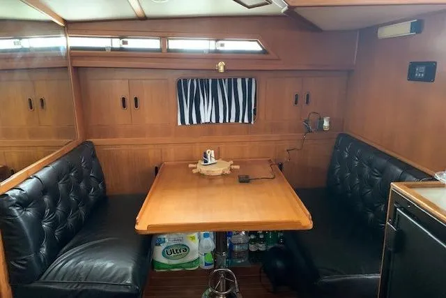 Slide: The Image of 1987 President 37 Sundeck interior with wood paneling, dining area, and black cushioned seating. - 35