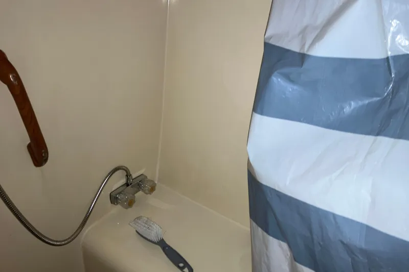 Slide: The Image of Shower area in 1987 President 37 Sundeck boat with striped curtain and cleaning brush. - 57