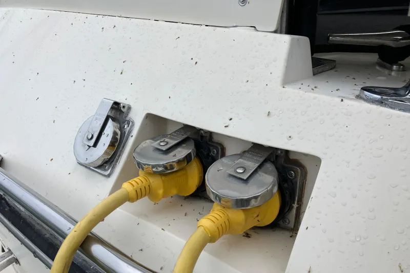 Slide: The Image of 1987 President 37 Sundeck boat with yellow power cables connected on a wet surface. - 8